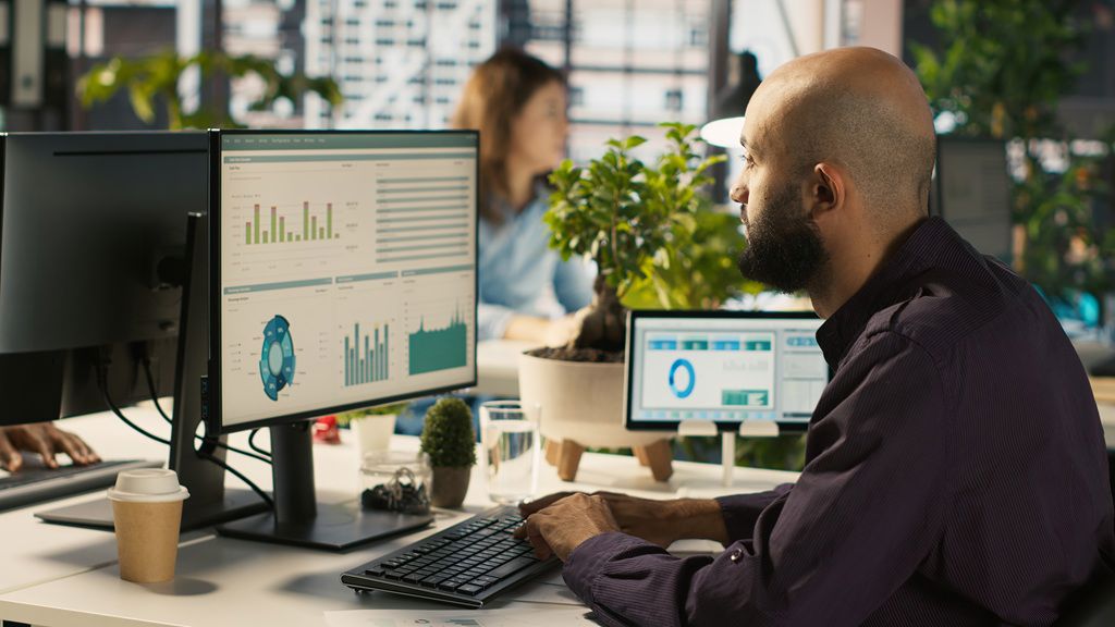 employee-editing-documents-desktop-computer-office-desk.jpg