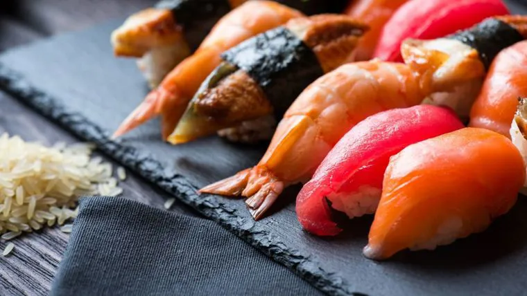 Nigiri di salmone e tonno serviti su un vassoio di ardesia