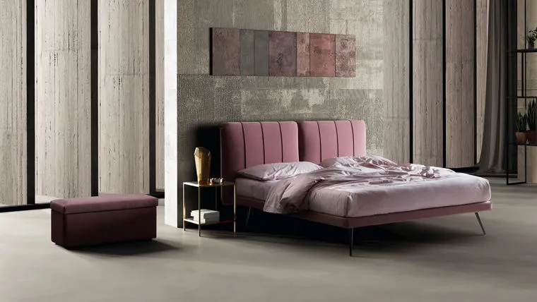 Una camera da letto arredata, con letto imbottito e parete in boiserie