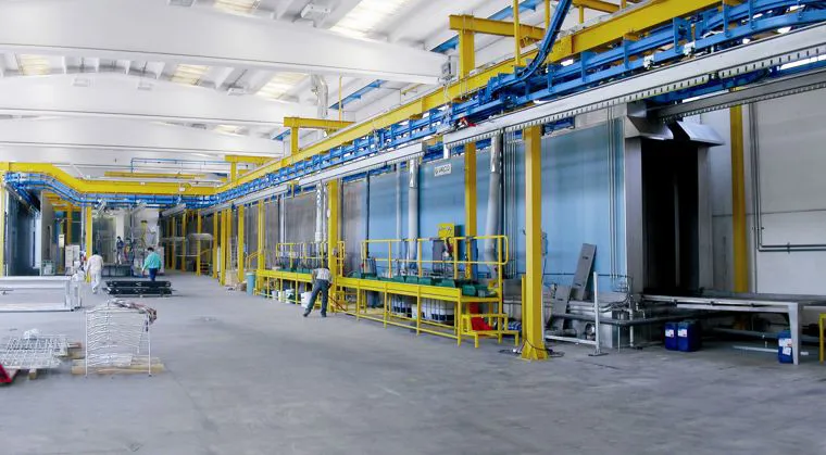 Una linea di verniciatura industriale vista per lungo dentro il capannone